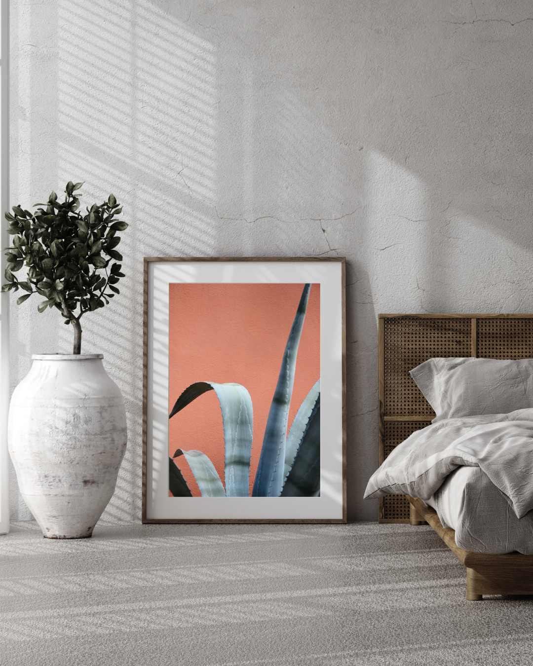 Cacti print in a bedroom with a shadow cast upon it rom the window. 