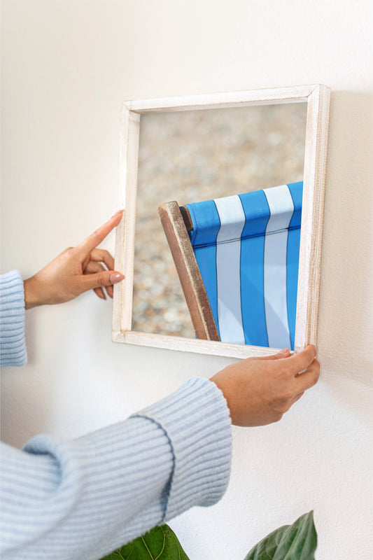 Deck chair photo showing person hanging it up on white wall. 